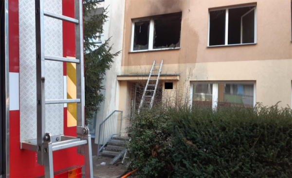 Požár zachvátil panelový dům v ulici U Stadionu v Lounech, policisté pomáhali při evakuaci